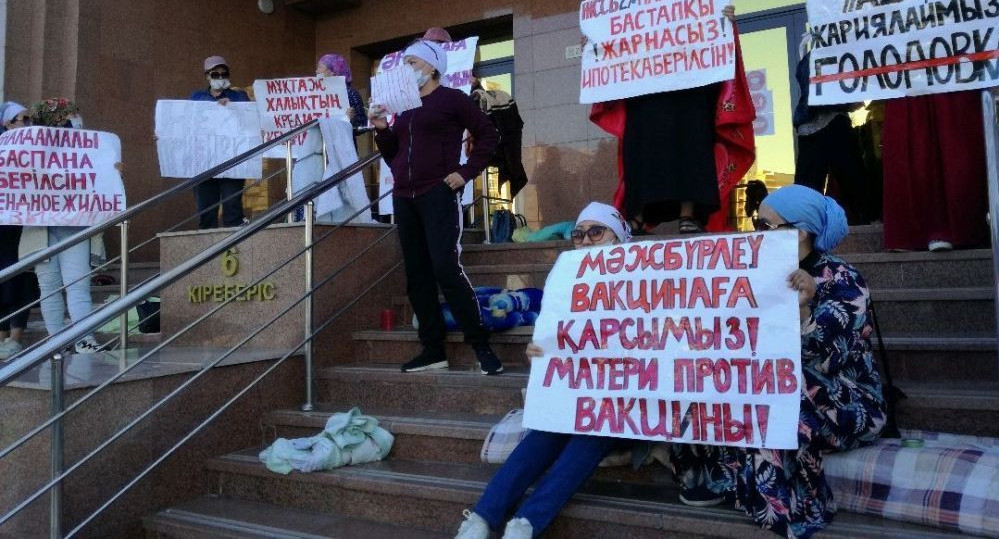 "Киімді жыртып тастады". Үнсіз митингке шыққан аналар министрліктің алдында түнеген