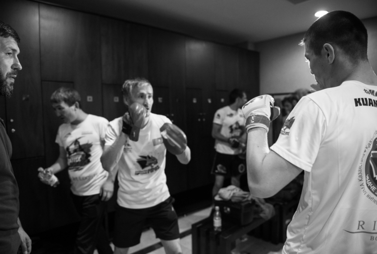 В ожидании своего выхода в раздевалке разогреваются другие спортсмены.